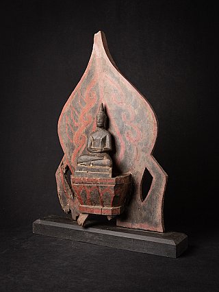 Wooden Burmese Buddha statue on panel in three-quarter view, showing the stepped base and panel edge