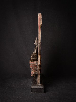 Burmese wooden Buddha statue in side profile, showing the relief depth and the panel thickness