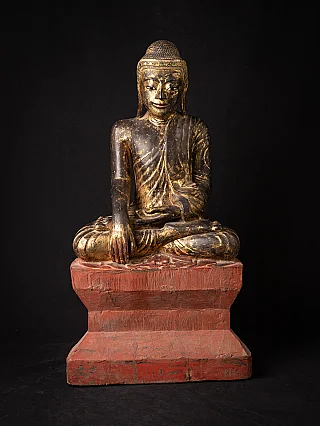 Burmese wooden Buddha statue, full front view on red base, seated in bhumisparsha mudra