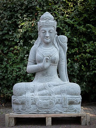 Dewi Tara stone statue from Indonesia, full front view, seated on a wooden pallet