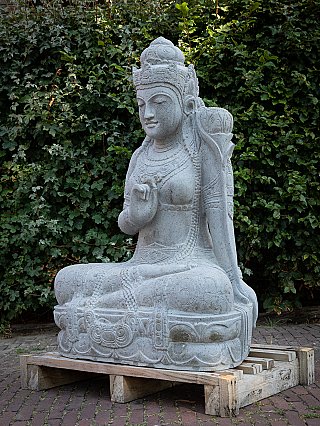 Dewi Tara stone statue from Indonesia, three-quarter left view showing the carved base