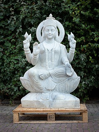 Large marble Lakshmi statue seated front view with four arms and circular halo