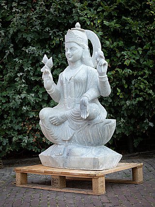 Marble Lakshmi statue in left three-quarter view, seated on base with four arms