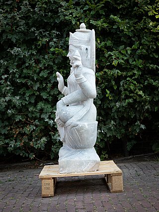 White marble Lakshmi statue in side profile, seated with raised hand and halo