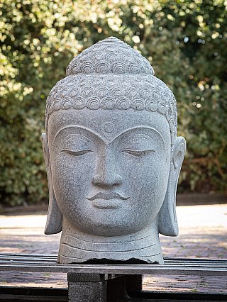 Indonesian Buddha head in grey stone, full front view with curled hair and elongated earlobes