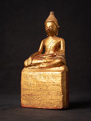 Thai wooden Buddha statue, seated three-quarter view showing the inscribed base