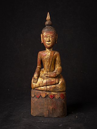 Thai wooden Buddha statue seated on a base, front view with worn gilding and red paint