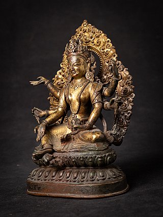 Gilt-bronze Vasudhara statue from Nepal in three-quarter left view, with ornate halo