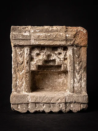 Antique Indian stone shrine with recessed niche and white residue, front view