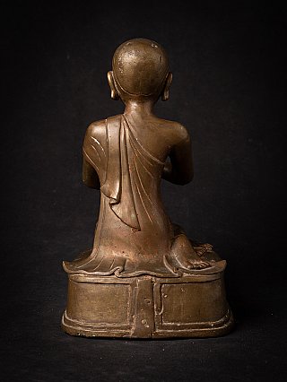 Burmese bronze monk statue, rear view showing robe drape down the back