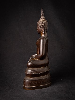 Thai bronze Buddha statue in seated posture, side profile with tall ushnisha