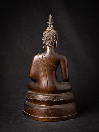 Thai bronze Buddha statue on pedestal, rear view showing back and hair texture