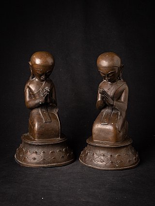 Pair of Burmese bronze monk statues seated with hands in namaskara mudra, front view