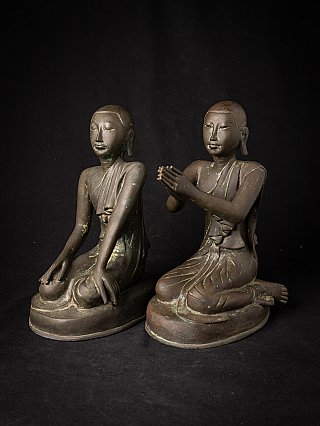 Burmese bronze monk statues, seated, three-quarter view with prayer gesture visible