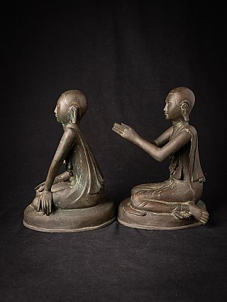 Pair of Burmese bronze monk statues, side profile with extended arms in namaskara mudra