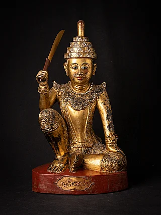 Burmese Nat statue in antique wood with sword, seated on red lacquered base, front view