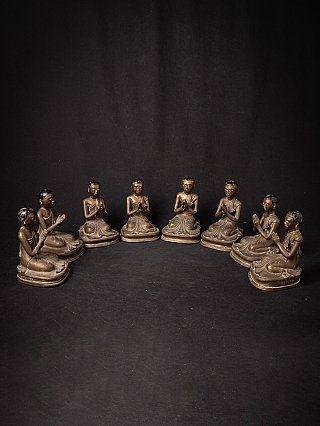 Set of eight Burmese bronze monk statues arranged in a semicircle, hands in namaskara mudra
