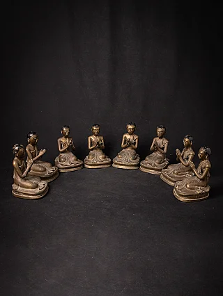 Set of eight Burmese bronze monk statues arranged in a semicircle, hands in namaskara mudra
