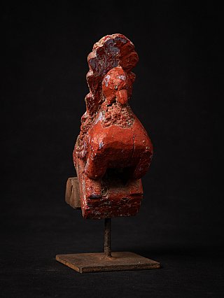 Antique Indian wooden bird statue with red paint, three-quarter front view