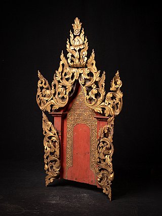 Burmese wooden temple panel, three-quarter view showing gilded scrollwork and red central niche
