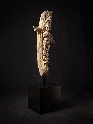 Antique wooden temple figure from India on stand, three-quarter view with wing motifs