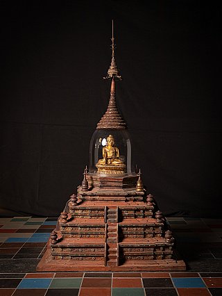 Wooden Burmese stupa with glass dome and gilded seated Buddha figure, full front view