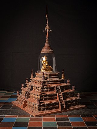 Antique wooden Burmese stupa with glass dome and gilded seated Buddha figure, three-quarter view