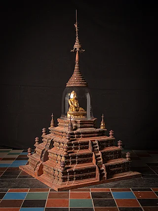Antique wooden Burmese stupa with glass dome and gilded seated Buddha figure, three-quarter view