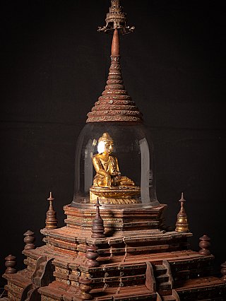 Detail of the glass dome with the gilded seated Buddha figure on the upper wooden base