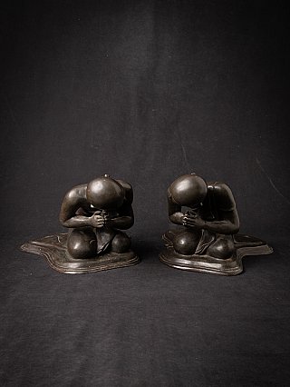 Pair of Burmese bronze monk statues seated with bowed heads and hands in prayer