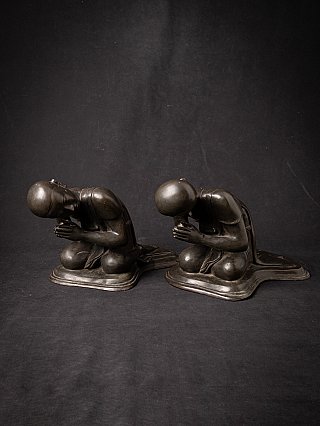 Pair of Burmese bronze monk statues in three-quarter view with hands in prayer