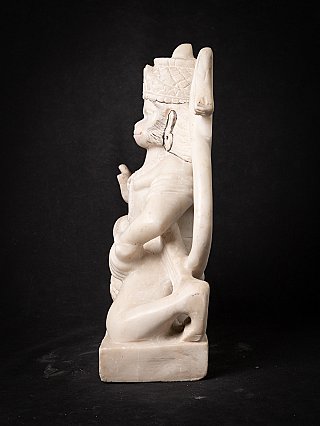 Marble Hanuman statue in side profile with raised hand and long tail behind the figure