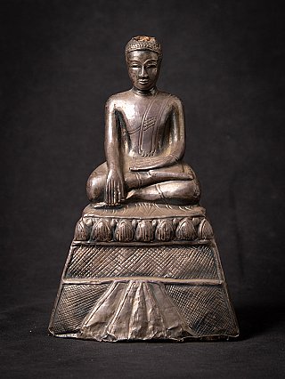 Thai Buddha statue seated in bhumisparsha mudra, full front view on tall base