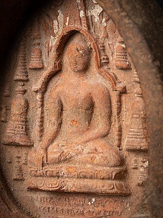 Buddha face and torso detail in relief, photographed at a slight angle