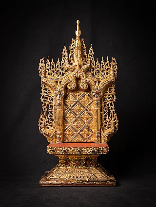 Antique wooden Burmese throne, full front view with gilded carving and red seat