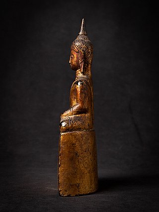 Thai wooden Buddha statue seated, left side profile view