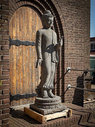 Lavastone Buddha statue from Indonesia, three-quarter right view on round base