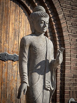 Upper body of Indonesian lavastone Buddha statue, raised hand in Vitarka mudra