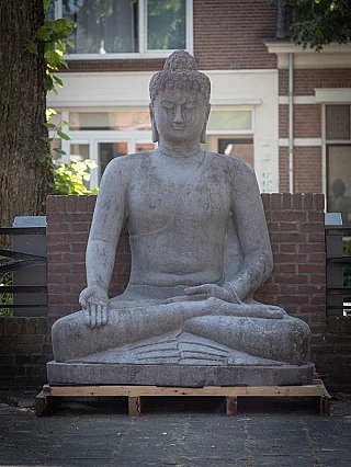 Buddha statue in Indonesian lavastone, seated, full front view with varada mudra hand