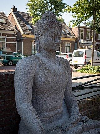 Indonesisch lavastenen Boeddhabeeld in zittende houding, driekwartaanzicht met gezicht en torso