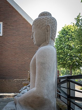 Seated Indonesian lava stone Buddha statue, left side profile view