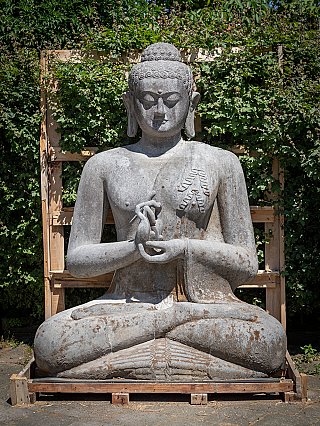 Grote lavastenen Boeddha uit Indonesië, zittend met dharmachakra mudra, frontaal