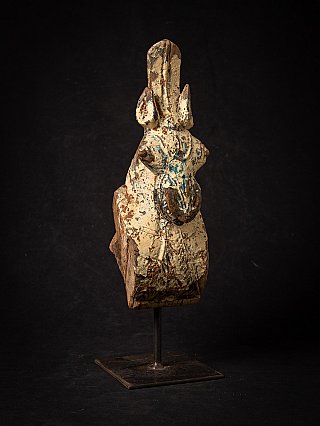 Wooden temple fragment of a horse head, angled front view on square metal base