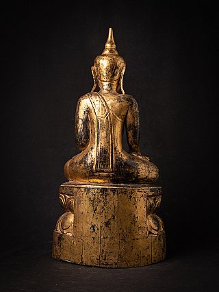 Antique Burmese Buddha statue in wood, rear view showing robe drape