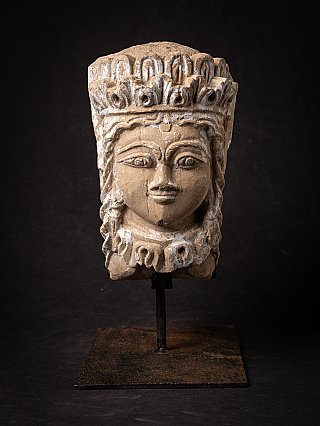 Antiker Kopf aus Indien auf Metallständer, Frontalansicht mit Kronenrand und weißen Farbresten