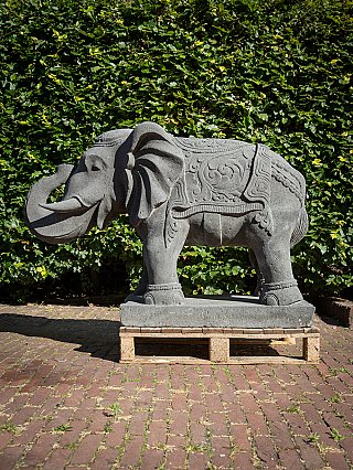 Lavastone elephant statue from Indonesia, left side view showing carved blanket pattern