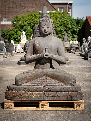 Grote Indonesische Boeddha van lavasteen op sokkel, zittend met dharmachakra mudra, frontaal