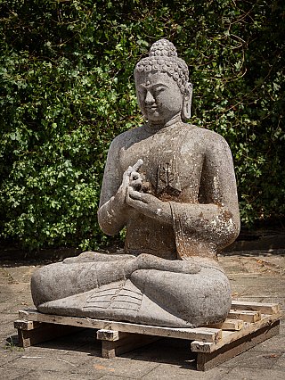 Indonesian lava stone Buddha statue with dharmachakra mudra, three-quarter left view