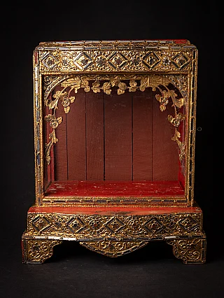Antique wooden Burmese Buddha temple, gilded carved frame and open niche, front view