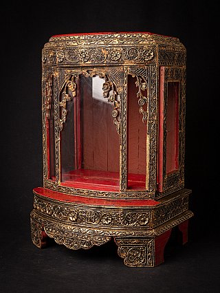 Wooden Burmese temple shrine in three-quarter view with glass panels and gilded borders